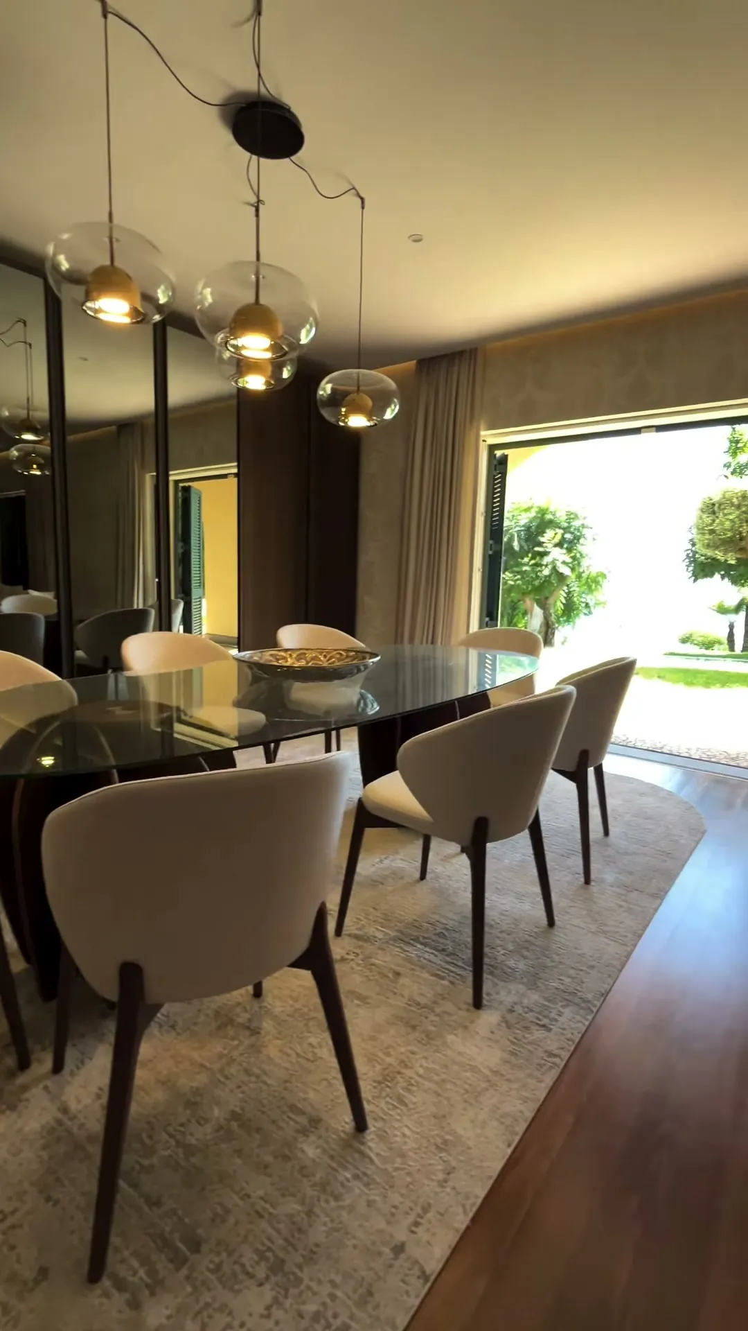 Sala de jantar com candeeiros de vidro e arco para o exterior